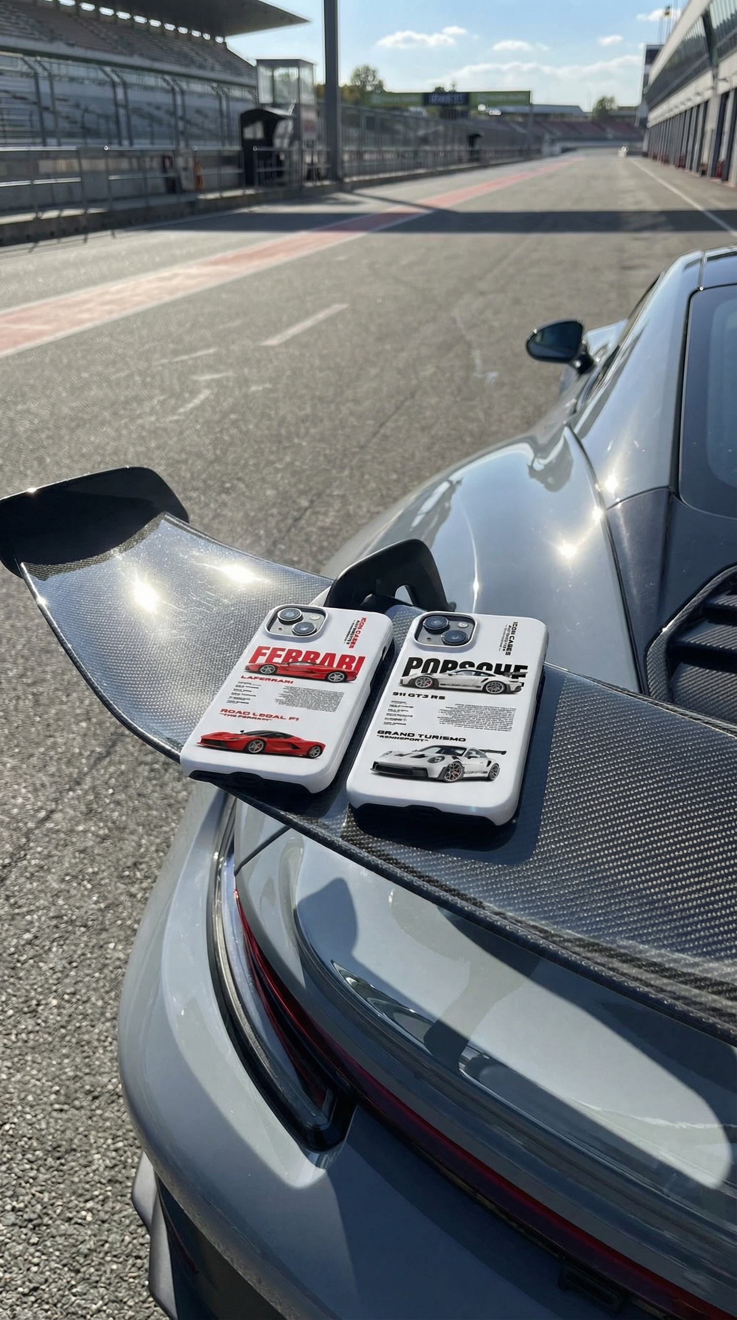 Two car phone cases on a car's spoiler with a race track background